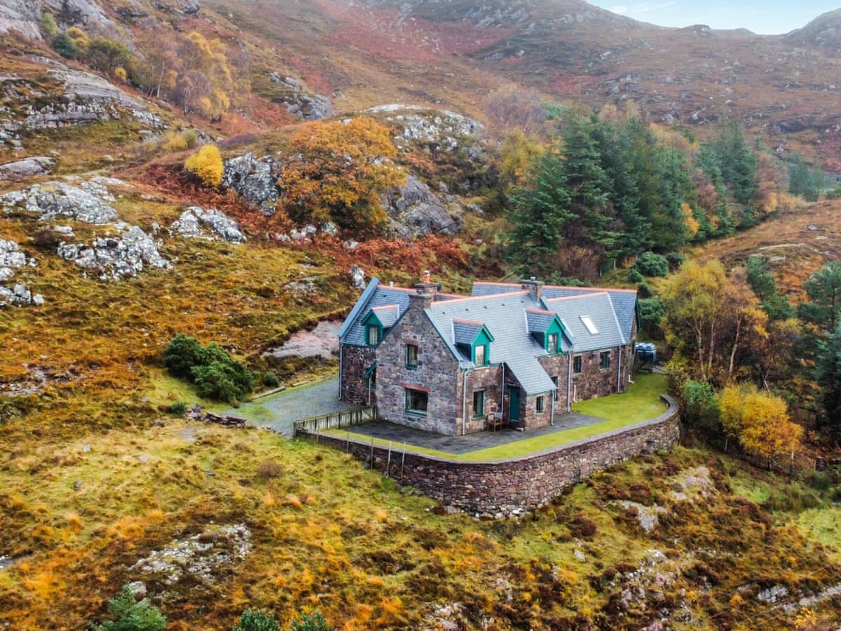 Rubha Lodge in Applecross, a stone cottage with green dormer windows beneath an autumn hillside